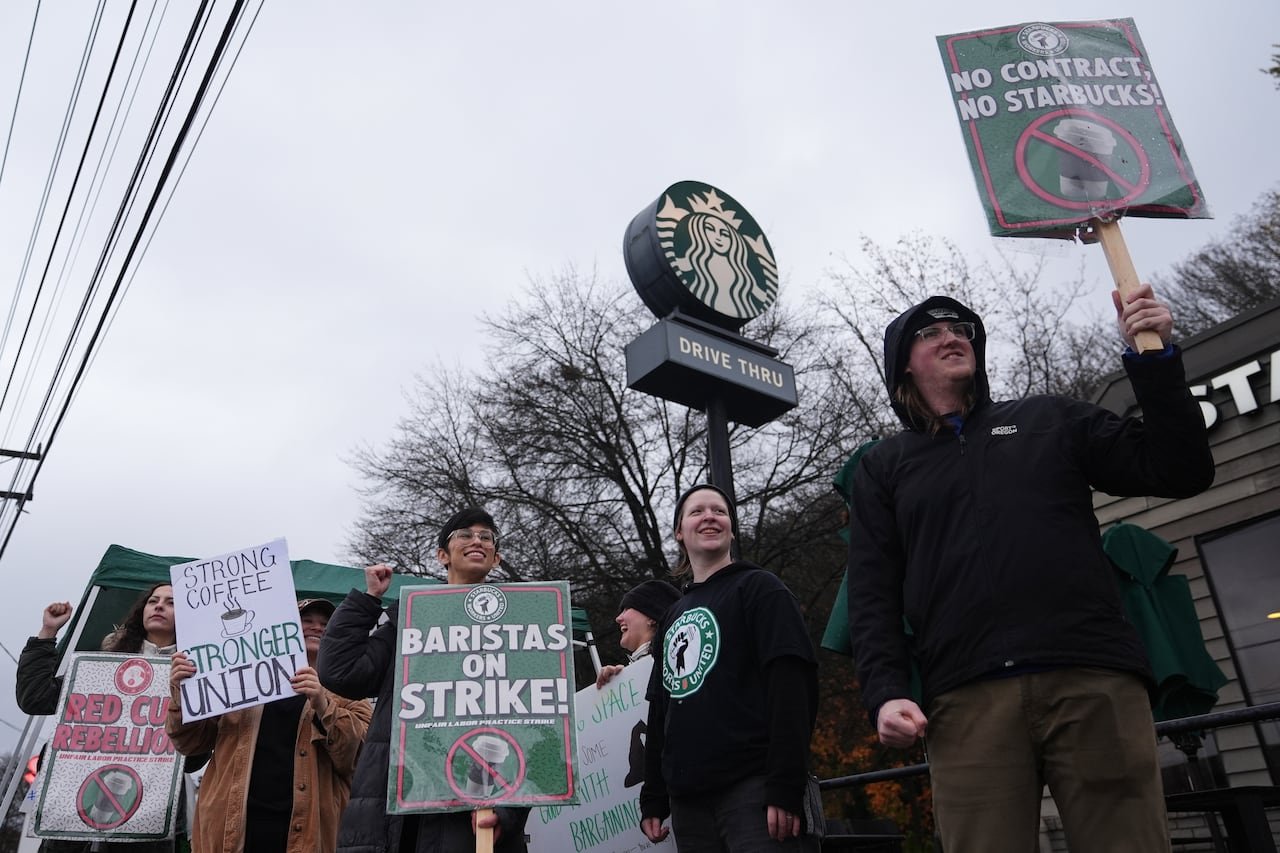 default-234 Workers hold picket signs outside of a Starbucks store.