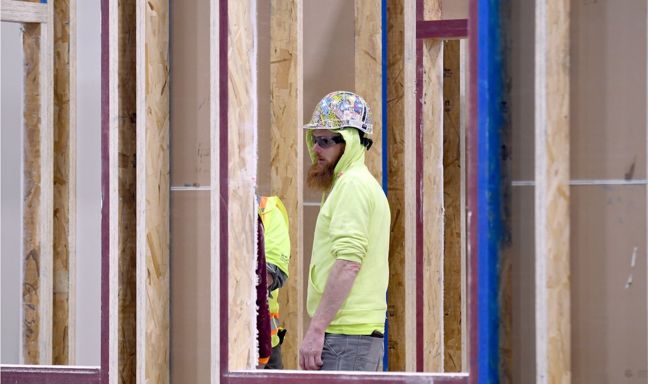 default-153 A worker is seen through the wood framing of a partially built home.